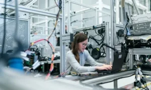 Engineer working on industrial equipment configuration in manufacturing lab
