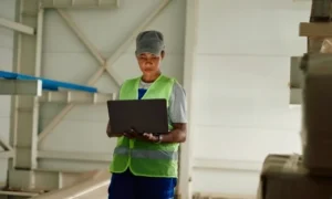 Warehouse manager using laptop for inventory and aftermarket resource management